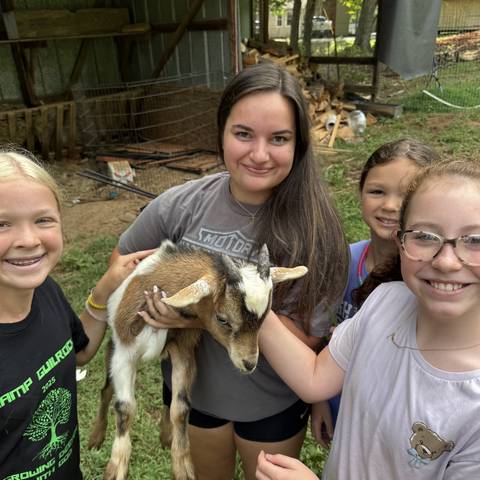 Campers holding a baby goat