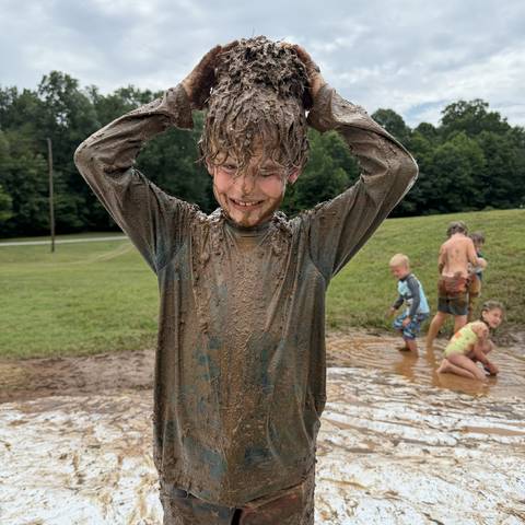 Camper covered in mud and smiling