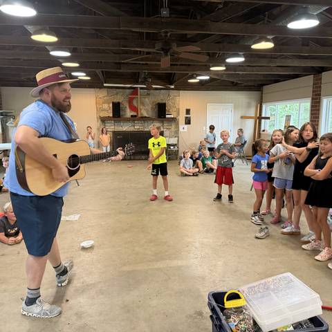 Counselor leading songs with a guitar