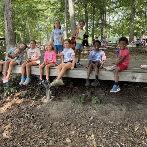 Campers sitting on a bench in the woods