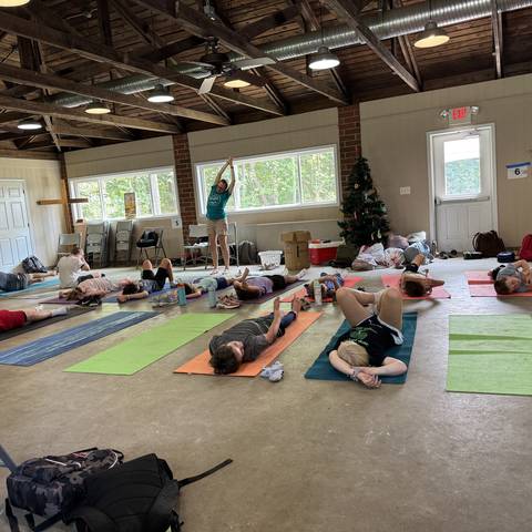 Campers resting on mats in the pavilion