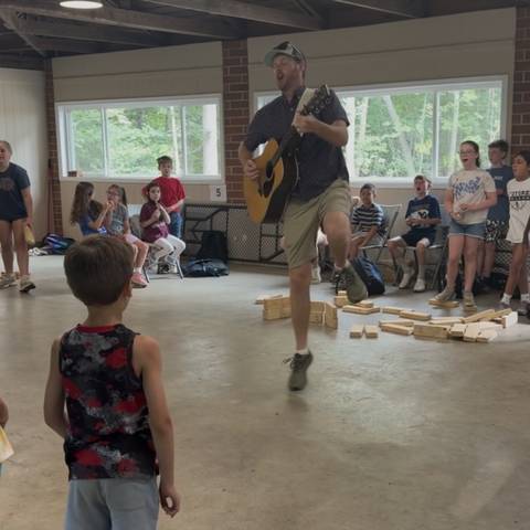 Counselor leading a game in the pavilion