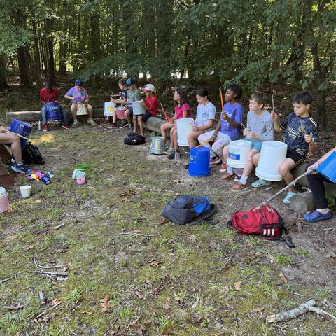 Campers sitting in a circle in the woods