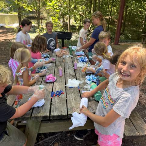 Campers doing crafts at the picnic tables